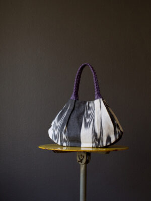 Handgemachte Schultertasche von KikieKoch Procida aus schwarz-weissem Ikat Stoff. Boden und Träger aus violettem Rindsleder.