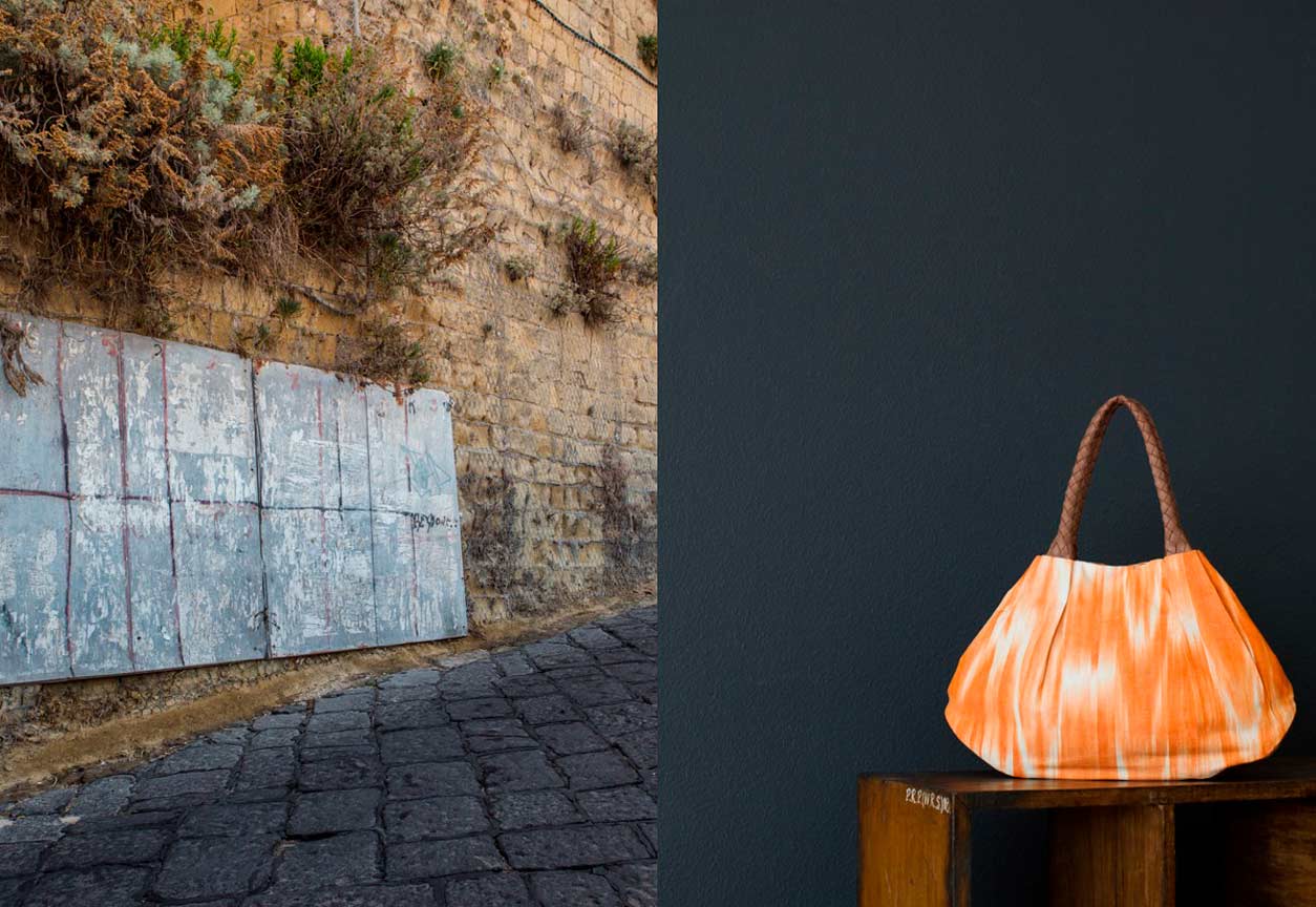 Alternativtext: Links: Salita al Castello Procida. Rechts: KikieKoch Tasche aus orange-weissem Ikat Stoff mit rundgeflochten Trägern und Boden aus braunem Rindsleder.